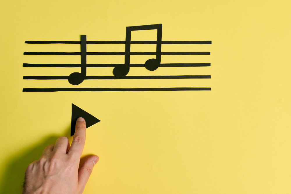 A Man’s Hand Touches the Play Button on a Yellow Background. Music Concept