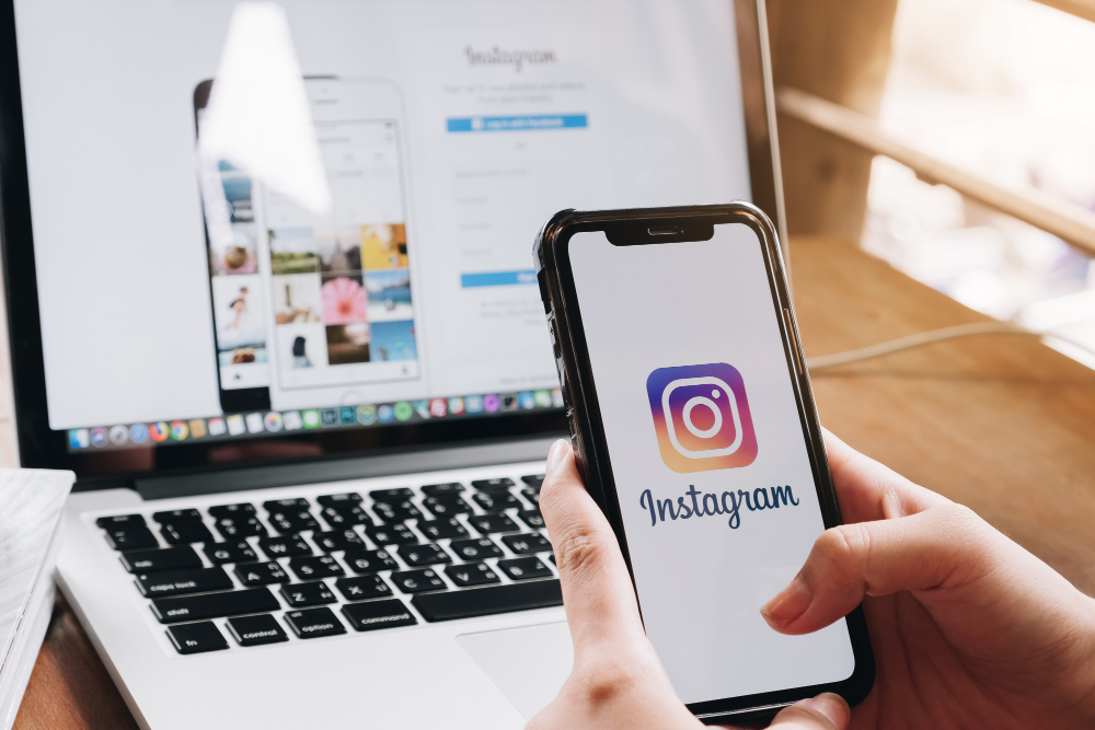 A Woman Holds an Smartphone With Instagram Application on the Screen at Cafe