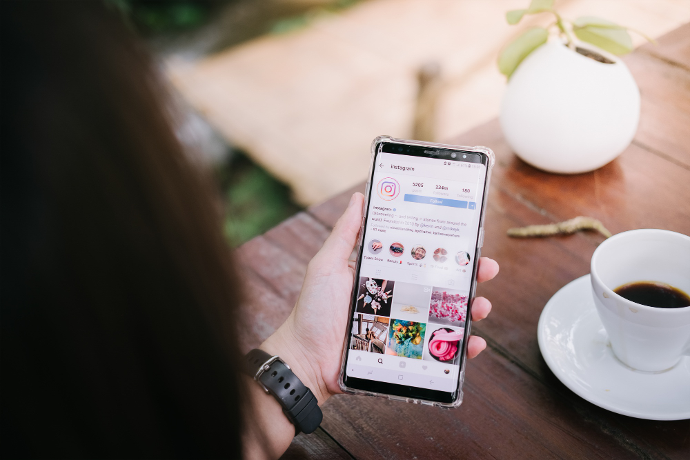 A Man Holds Samsung Note 8 With Instagram Application on the Screen