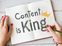 Woman Writing Content Is King on a Notebook