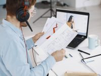 Man Sitting in Living Room at Home. Guy Enjoying Studying Using Laptop and Headset.