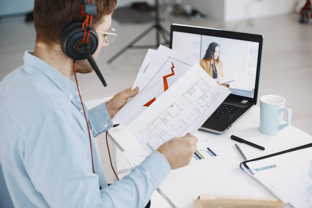 Man Sitting in Living Room at Home. Guy Enjoying Studying Using Laptop and Headset.