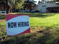 a now hiring sign in front of a building job search, resume, career transition