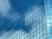 a very tall glass building with a clock on it’s side cloud computing, scalability, business growth