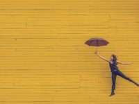 woman holding brown umbrella happy streaming, laptop couch, watching movies