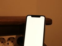 a cell phone sitting on top of a wooden table snapchat user, phone screen, avoiding spotlight