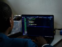 a man sitting in front of a laptop computer ai assistant, coding project, developers, ubuntu code