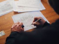 person writing on white paper hp spectre, portable laptop, touchscreen design