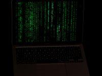 a laptop with a green screen hacker, cybersecurity, data breach