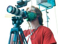 a man in a red shirt and a camera AI video software, video editing, digital media