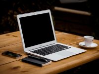 MacBook Air near mug on table wave invoicing app, financial freelancers, invoicing on laptop