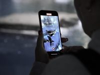 a man holding a cell phone pokemon go spoofing, smartphone gps, map app