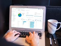 person using macbook pro on black table performance dashboard, employee metrics, business analytics
