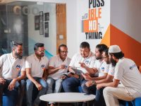 A group of men sitting around each other people laughing, campaign team, brainstorming