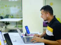 man in black and yellow polo shirt using macbook pro team research laptop office data