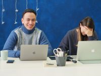 woman in gray sweater using silver macbook people laughing, campaign team, brainstorming