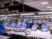 Workers are at an industrial clothing factory. nissan usa factory production assembly