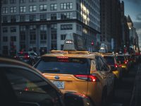 Yellow taxis in city traffic during the day uber ride types, different vehicles, transportation options