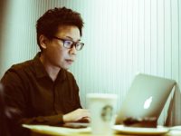 a man sitting at a table using a laptop computer content writing analytics seo marketing