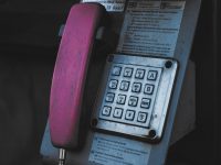 An old style phone is attached to a wall telecom bills, cost analysis, invoice auditing