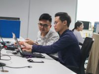 Enterprise SEO agency: Scaling for Large Sites two men sitting at a desk looking at a laptop teamwork office monitors seo strategy