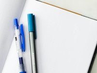 How to Design a Startup Logo Without Hiring a Designer a few pens on a white surface brainstorming notes, brand adjectives list, startup planning desk