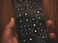 a person holding a cell phone in their hand smartphone home screen, app widgets, shortcut icons, finger tapping screen