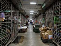 Closed market stalls with metal security shutters and boxes. warehouse interior inventory barcode scanner
