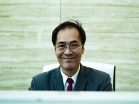 man wearing formal suit sitting and smiling chief of staff, tech company, executive team