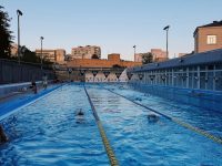 The Rising Costs And Opportunities Created By Lifeguard Shortages And How Communities Can Respond A large swimming pool with people swimming in it public pool with few staff, closed lanes, community swimmers