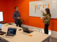 When Businesses Should Begin Marketing In 2026 | 7 Growth Indicators That Predict Early Success a man and a woman standing in front of a whiteboard business team meeting analytics dashboard product metrics