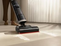 A person using a cordless vacuum cleaner on a floor. hardwood floor cleaning, carpet steam cleaning, tile grout scrubbing, home maintenance interior