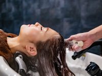 Beauty Salon Guide: Why Hydrodermabrasion Facial Machines Are Trending In 2026 a woman getting her hair washed in a salon hydrodermabrasion facial, skincare treatment, beauty salon