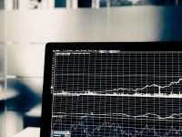 turned on flat screen monitor data analytics graph on laptop, cloud network diagram, business branding materials