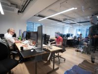 a group of people sitting at desks in an office modern office startup team working, artificial intelligence company, tech startup workspace