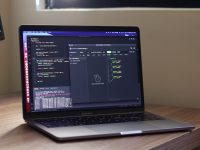 a laptop computer sitting on top of a wooden desk native access interface, plugin installation manager, music software dashboard