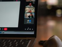 Laptop screen showing a video conference with multiple participants. team video call laptop crm dashboard online meeting