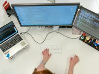 person using macbook pro on white table modern office dashboard analytics screen team collaboration