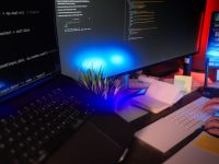 Programmer coding at a desk with several monitors. developer coding laptop database schema on screen modern workspace