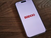 A badoo phone sitting on top of a wooden table badoo app screen profile settings smartphone