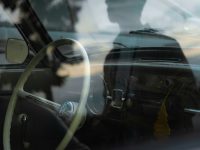 a reflection of a man sitting in a car car dash cam installed windshield front and rear camera setup