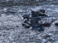 black stones on body of water during daytime balanced stones river, flowing water, natural harmony